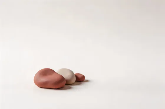 White And Brown Egg Sitting On Top Of A White Surface