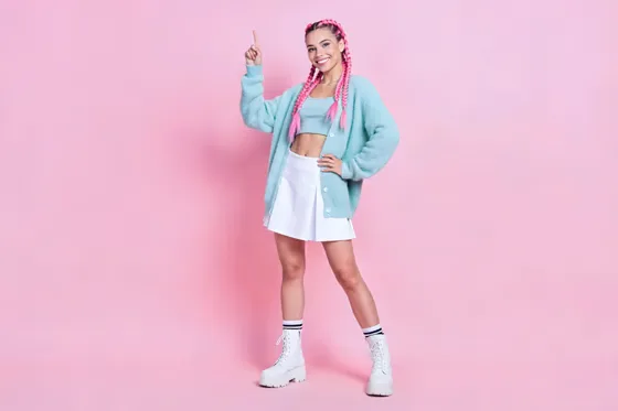 Woman In A Blue Sweater And White Skirt Posing With Her Hands Up