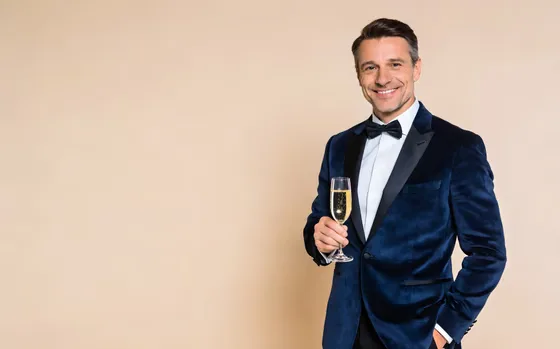 Man In A Tuxed Suit Holding A Glass Of Wine