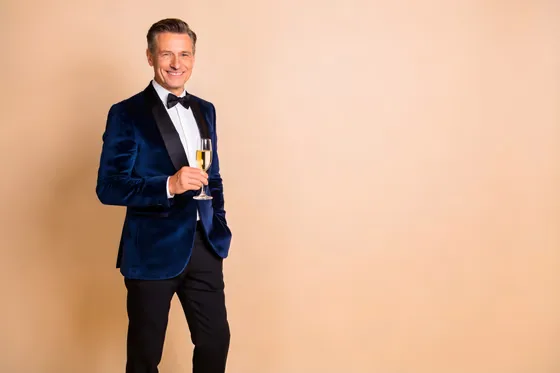 Man In A Tuxed Suit Holding A Glass Of Champagne