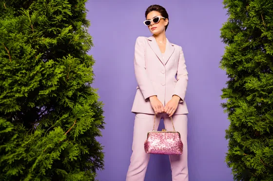 Woman In A Pink Suit And Sunglasses Holding A Pink Purse